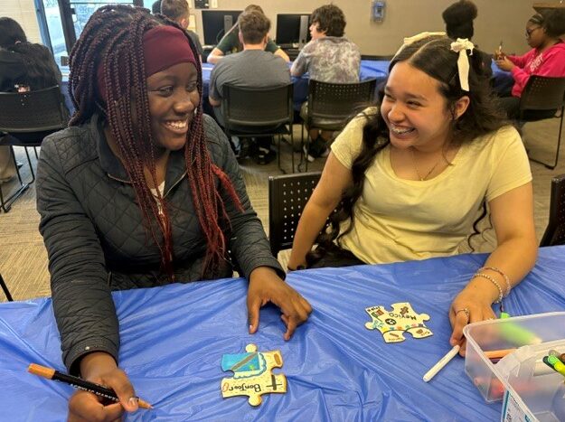 Two students smile at each other as they participate in a workshop with Jewish Museum Milwaukee and Artist Jac Lahav