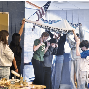 Student to Student presenters demonstrate the Jewish wedding tradition of a chuppah to local middle school students.